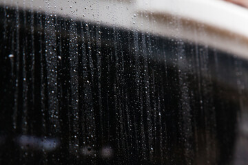 Drops of dew on a gray glossy surface.