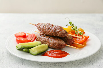 Plate of skewers with tasty lula kebab and vegetables on light background
