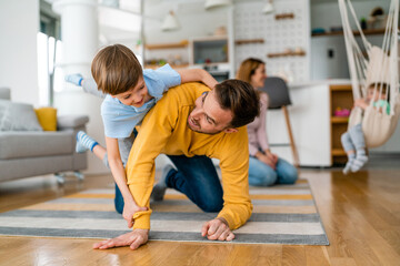 Fototapeta premium Young happy family being playful and having fun at home