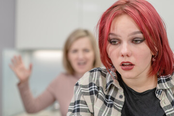 Family conflict. Angry mother screams at crying teen daughter