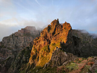Amazing, sunset over a pyramid shaped mountain peak.  Beautiful golden orange sunlight. Travel the...