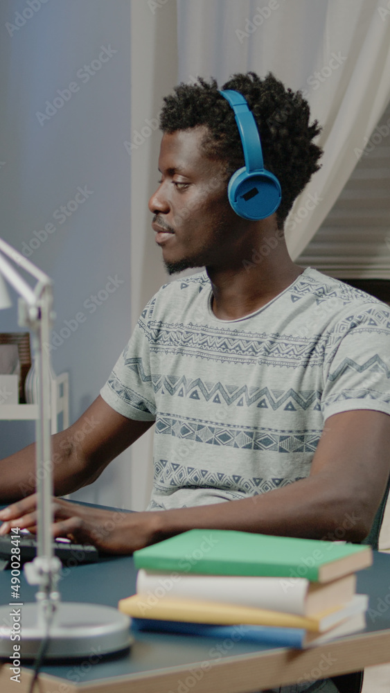 Poster engineer with headphones creating building model on computer. architect working with software to des