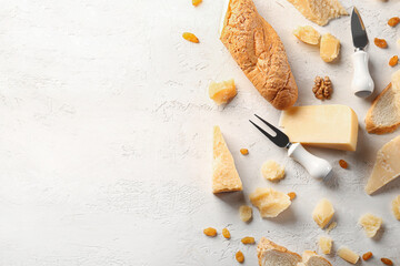 Fototapeta na wymiar Pieces of tasty Parmesan cheese and bread on light background