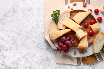 Wooden board with pieces of tasty Parmesan cheese and bread on light background