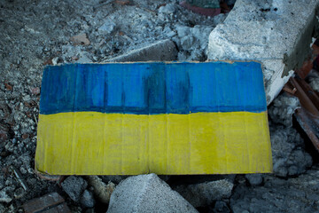 Ukrainian flag in the rubble, solidarity with the Ukrainians. Russia's attack on Ukraine