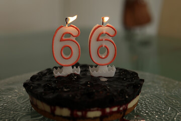 Birthday cake. Birthday cake with burning candle number 66.