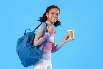 African-American female student with coffee on blue background