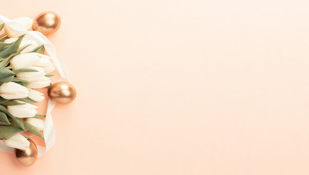 Easter eggs Golden color with spring white tulips on pastel pink background in Happy Easter decoration. Festive decoration in flat lay banner. - Powered by Adobe