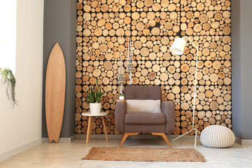 Interior of modern living room with wooden surfboard, armchair and standard lamp