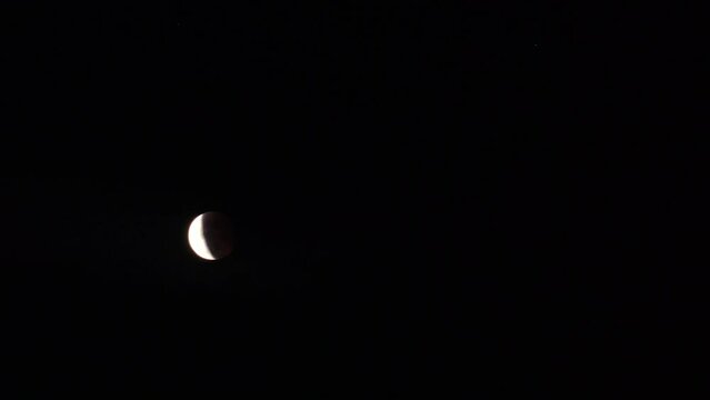 NAHA, OKINAWA, JAPAN - 26 MAY 2021 : Total eclipse of super blood moon seen in northern Japan and Okinawa. A total lunar eclipse during which the full moon hides in the Earth's shadow. Time lapse shot