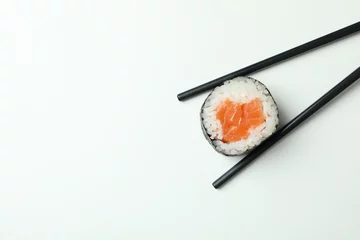 Gordijnen Chopsticks with maki on white background, space for text © Atlas