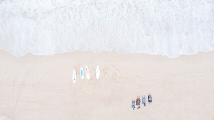 tourist man lying on the sand and four surfboard are placed on the sandy Beach and sea wave aerial...