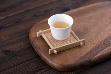 A cup of Gongfu tea is on the cutting board
