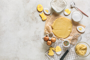 Fresh dough and ingredients for preparing Easter cookies on light background