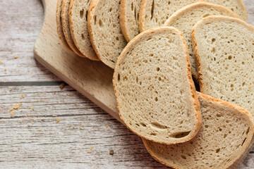 Sliced ​​fresh bread and cutting knife on rustic table