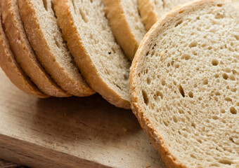 Sliced ​​fresh bread and cutting knife on rustic table
