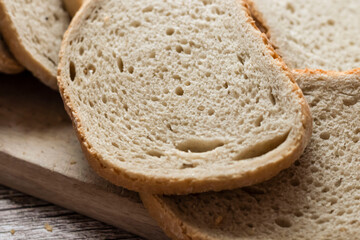 Sliced ​​fresh bread and cutting knife on rustic table