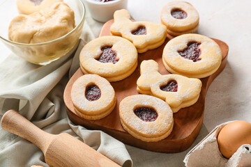 Wooden board with tasty Easter cookies on table