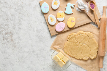 Fresh dough and tasty Easter cookies on light background