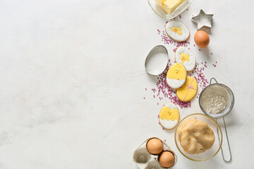 Tasty Easter cookies and ingredients on light background