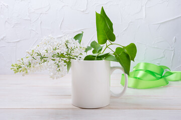 White coffee mug mockup with green ribbon and white lilac