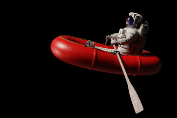 astronaut in red dinghy, isolated on black background - obrazy, fototapety, plakaty