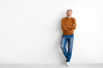 Portrait of happy mature man posing at white studio