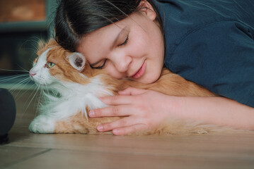 Miłość okazywana przez dziewczynkę swojemu kotu. Pieszczoty z kotem . Kocia mama. Dziewczynka przytula ładnego kotka z piękną wyczesaną sierścią