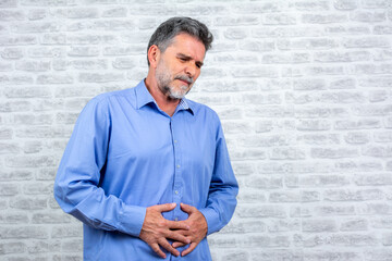 Mature man having a stomachache. Old male having strong abdominal ache, stomach ulcer disease,...