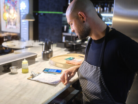 Chef reading the list of tasks to prepare the menu in a restaurant