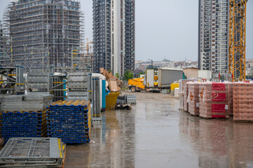 Busy construction site and lots of construction material, equipment, tools, heavy machinery and...