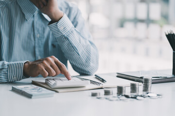 Asian men are calculating about finances about the cost or future investment at home while the...