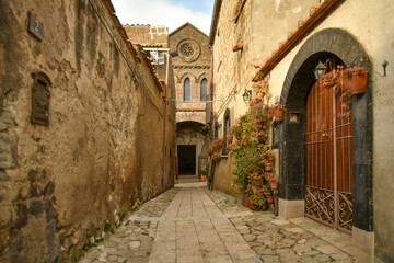 A narrow street among the old stone houses of the oldest district of the city of Caserta Vecchia, Italy.