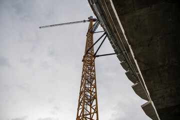 Fototapeta premium Closeup view of yellow Crane Access Ladder, steel staircase, leading to crane cabin on top. Construction site of high-rise structure buildings, skyscraper.