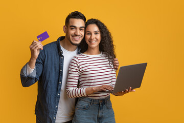 Online Shopping Concept. Happy Arabic Couple Using Credit Card And Laptop