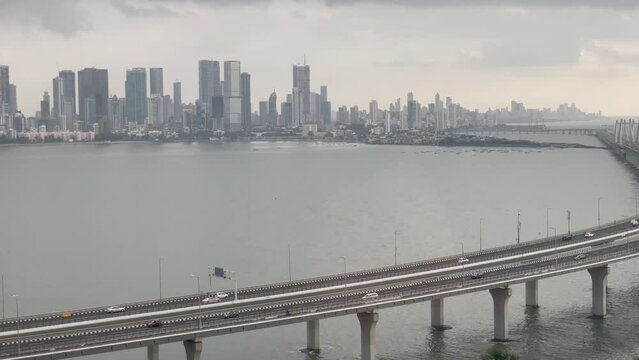 Vehicles Driving Through Bandra Worli Sea Link With Mumbai Skyline In The Distance In India. - wide panning
