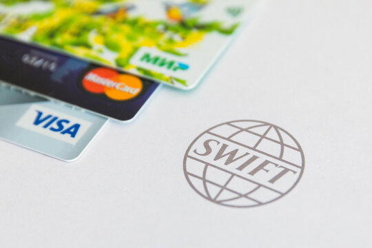 March 1, 2022 - Saint-Petersburg, Russia. Disabling Russia from Swift. Bank cards and swift system logo