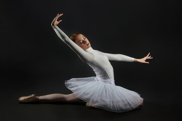 elegant ballerina made a deflection. photo shoots in the studio on a dark background