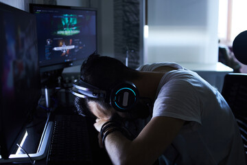 a young 30-year-old gamer is sitting at a computer, playing computer games, nervous, angry, worried.selective focus with low depth of focus