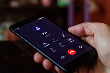 Dialing 911, call 911. Emergency concept: man using a digital phone with emergency call on the...