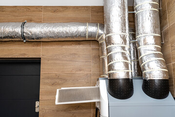 Home mechanical ventilation with heat recovery hanging on the wall, visible dirty filters sticking...