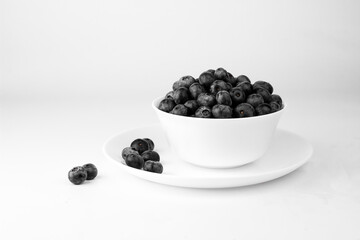 Blueberry in white bowl and plate on white background.