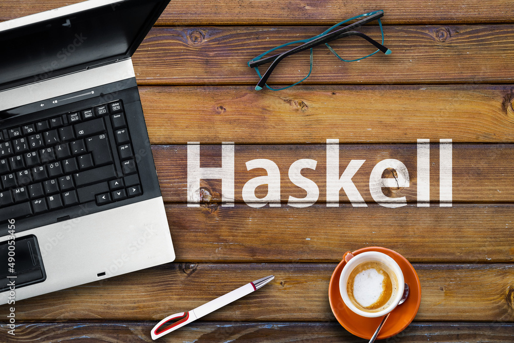 Poster haskell programming language. word haskell on wooden desk and laptop
