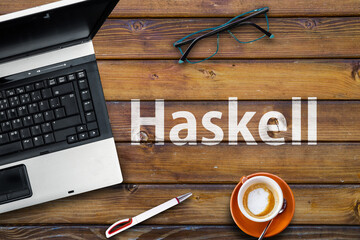 Haskell Programming Language. Word Haskell  on wooden desk and laptop
