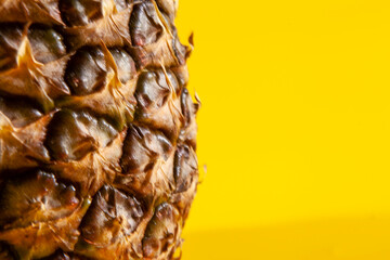 Beautiful fresh pineapple isolated on yellow background. Summer seasonal fruit design idea pattern concept. Copy space, close up