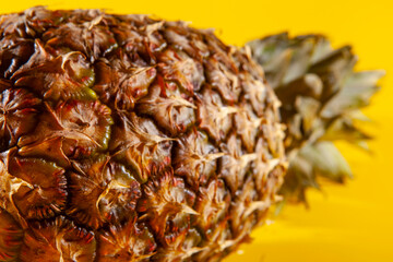 Beautiful fresh pineapple isolated on yellow background. Summer seasonal fruit design idea pattern concept. Copy space, close up