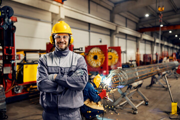 Portrait of a smiling heavy industry worker posing in facility.