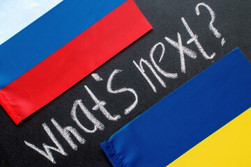 Fototapeta na wymiar The Ukrainian and Russian flags. Diplomatic relations between Ukraine and russia. War conflict concept image. What's next hand writing chalk text on black chalkboard. military conflict Geopolitical
