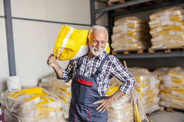 Old worker is holding a sack on his shoulder and relocating it with minimum effort.