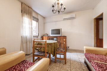 Vintage room with a stretcher table in the center and sofas with cushions upholstered with horrible fabric